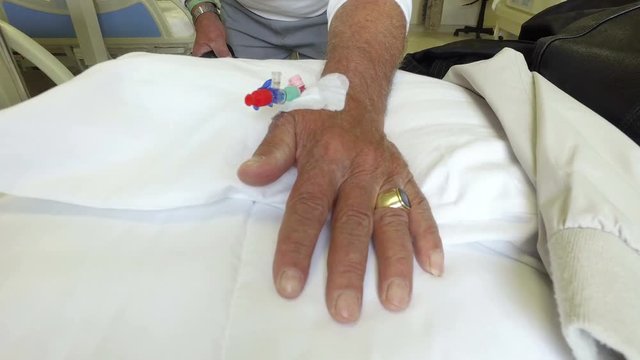 Old man patient hand with needle drip for IV solution 