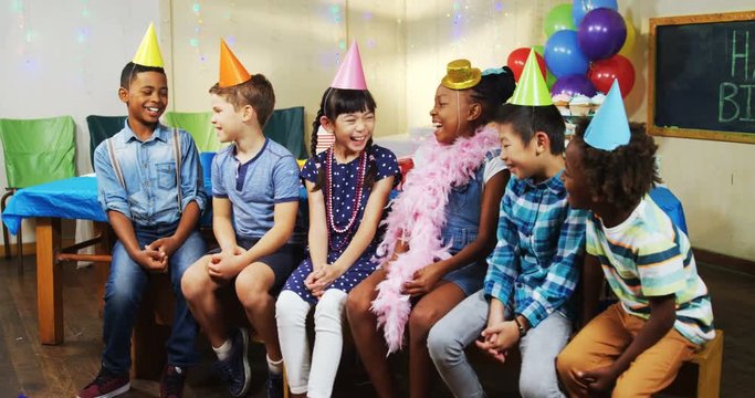 Kids smiling while sitting together during birthday party 