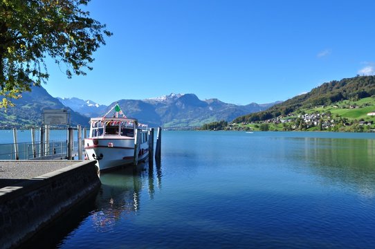 Passagierschiff an Schiffsteg, am Sarnersee im Kanton Obwalden. Im Hintergrund die Schneeberge vom Berner Oberland mit Berg Brienzer Rothorn