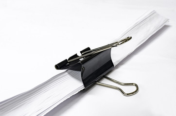 Paper with black clip, office background with selective focus