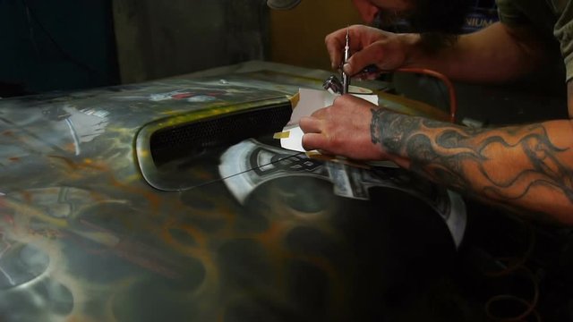 Painting using airbrush on the hood with a template