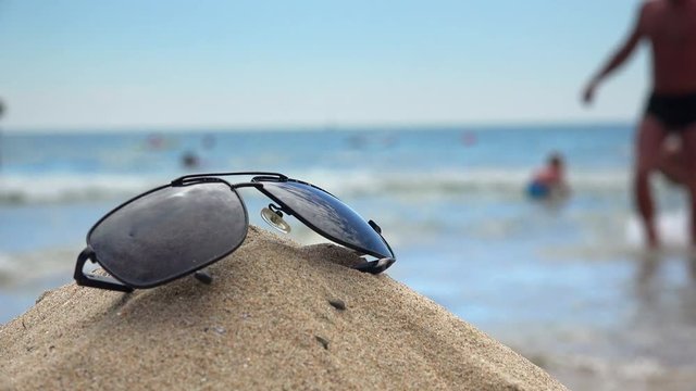 Points lying on the sand. In the sunglasses reflected the 
