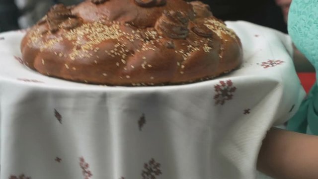 Close-up - wedding tradition unknown woman hold a loaf for meeting of newlyweds before the start of banquet