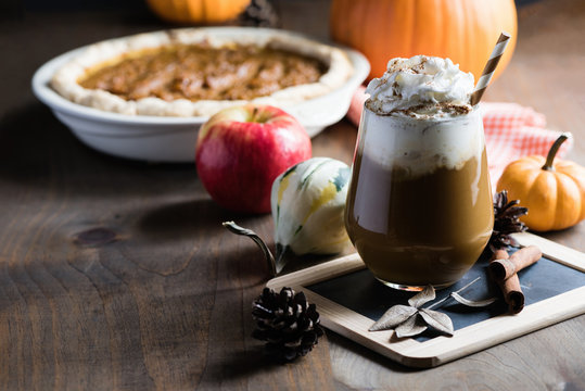 Pumpkin latte with spices, coffee autumn of fall drink with pumpkins, Thanksgiving table, copy space, selective focus