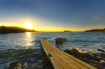 Small Boat and Wooden Pier at sunset
