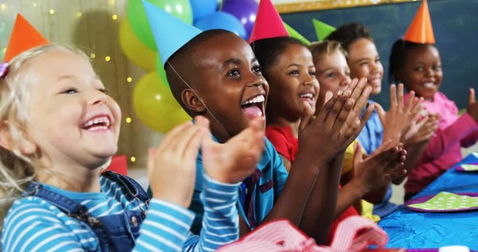 Kids clapping their hands during birthday party 