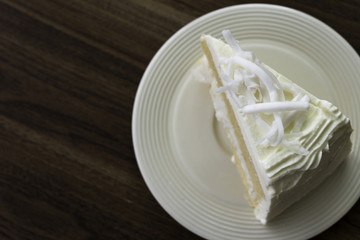 A piece of coconut cake on white dish