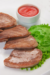 Boiled beef tongue with vegetables is served on a plate