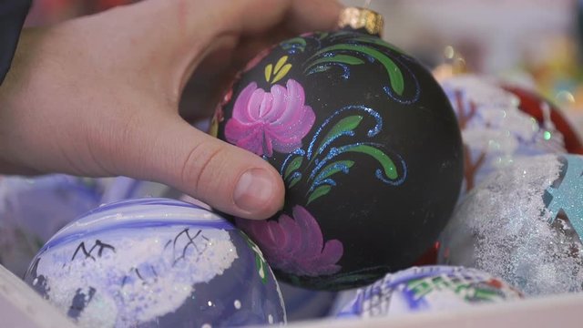 Close-up of New Year theme man's hand taking black glass bowl with patten and slowly rotate it