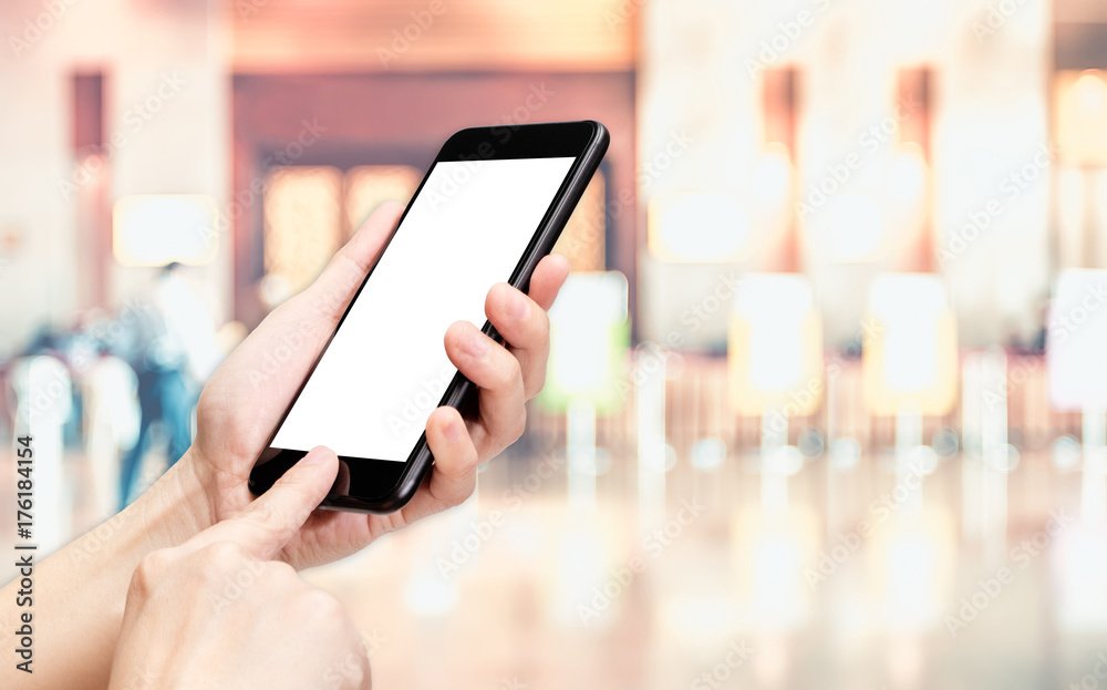 Leinwandbilder Hand click mobile phone with blur office corridor hall way background bokeh light,White screen mock up template for adding your design or your text.