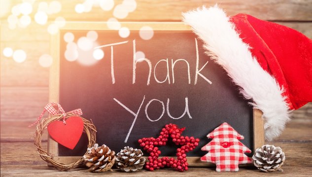Thank you text on slate with decorations on wooden table