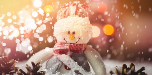 Snowman and pine cone on snow