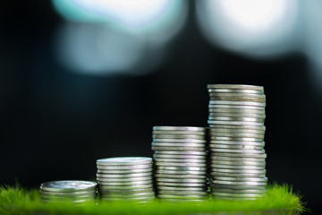 Stacks of coins on green grass, finance and business concept, shallow focus.
