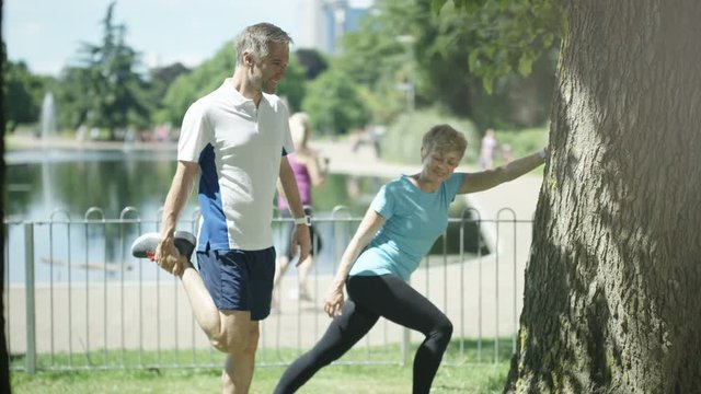  Healthy & fit mature couple working out in the park.