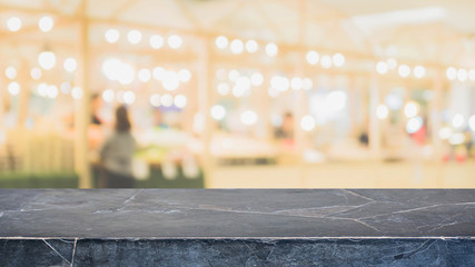 Black stone table top on blurred with bokeh shopping mall background - can be used for display or montage your products.