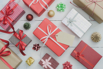 Paper tag with Christmas and New Year holidays gift box with decorative ornament on white wooden...