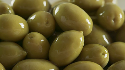 Large shiny green olives macro background