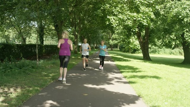  Active mature man & woman running in the park stop to get breath back