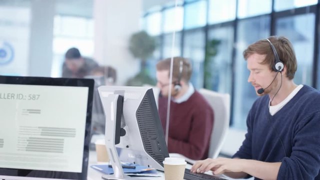  Multiracial telesales team talking to customers in busy call center