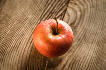 Ripe red apple on rustic dark wooden table