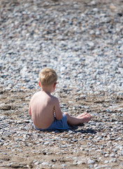 Fototapeta na wymiar little boy by the sea on the beach