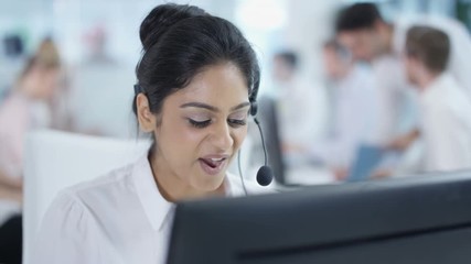  Friendly customer service adviser talking to a customer in busy call center
