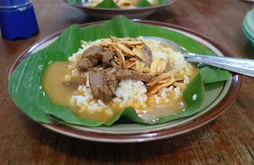 Nasi gandul. Traditional food from Pati, Central Java, Indonesia. Served with curry, ketchup and always accompanied with meat slices or eggs.