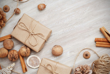 Christmas New Years gift box with red ribbon bow. Tangerines pine cones walnuts fir tree branches. Greeting card template dark background copy space.