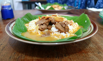 Nasi gandul. Traditional food from Pati, Central Java, Indonesia. Served with curry, ketchup and always accompanied with meat slices or eggs.