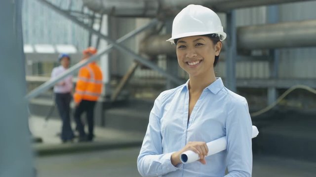  Portrait smiling engineer on site with colleagues working in background
