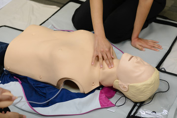 check pulse - CPR First Aid Training with CPR dummy in the class