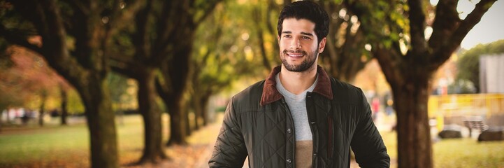 Fototapeta premium Composite image of smiling man with hands in pockets posing