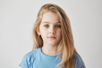 Close up portrait of beautiful little girl with light long hair and big blue eyes looking in camera with relaxed expression. - Powered by Adobe