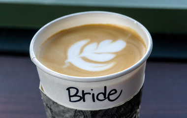 To go coffee mug with bride text written on cup with flower shape foam latte