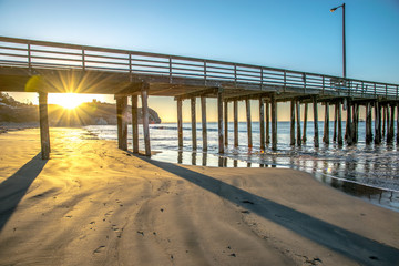Sunrise shinning through Avila Beach pier on California's Central Coast
