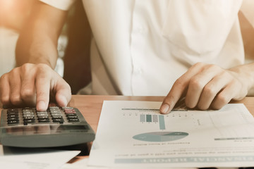 Man hand pointing stock market document with using calculator do