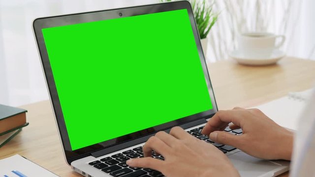 4K : Woman hand typing on a laptop computer with a key green screen.