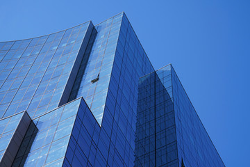 Fototapeta na wymiar Low angle view of modern office building in blue color