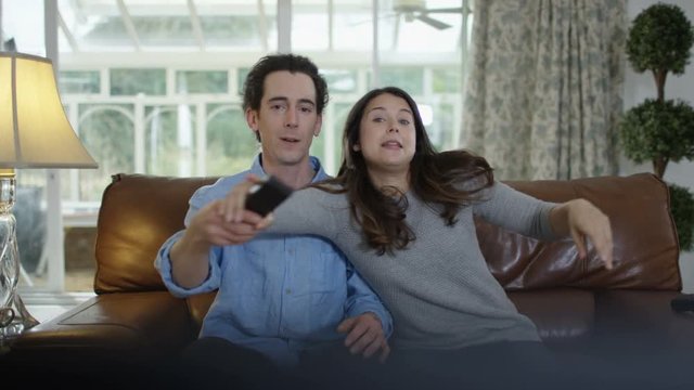  Couple fighting over the remote control in front of TV