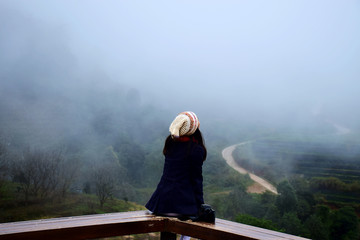 Girl sitting in the scenery with fog