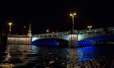 Fototapeta na wymiar Night cityscape with river and bridge in Saint-Petersburg .