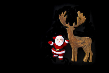 Santa clause with wooden reindeer on black background