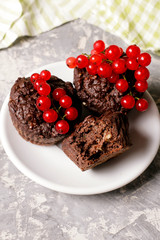 chocolate muffin with redcurrant on white. healthy dessert