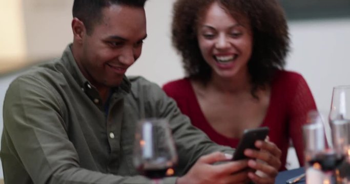 Couple looking at smartphone together at a meal
