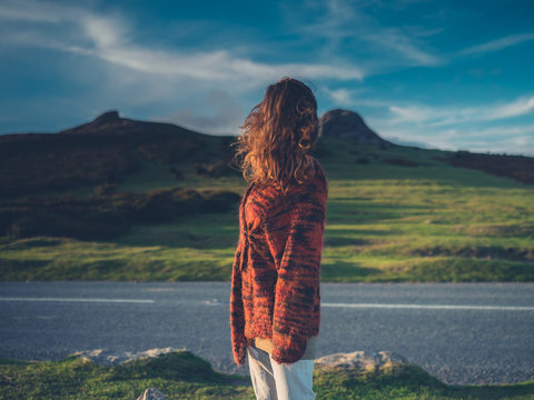 Young woman standing by road in wilderness