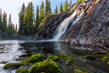 Fototapeta na wymiar Beautiful waterfall with stones on foreground
