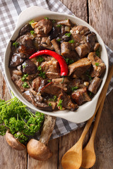 Stew beef with wild forest mushrooms and chili close-up. vertical top view