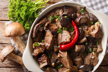 Stew beef with wild forest mushrooms and chili close-up. Horizontal top view