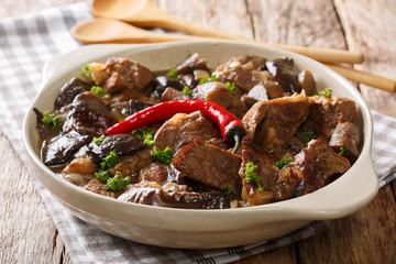 Spicy beef with wild mushrooms, chili pepper and gravy closeup in a bowl. horizontal
