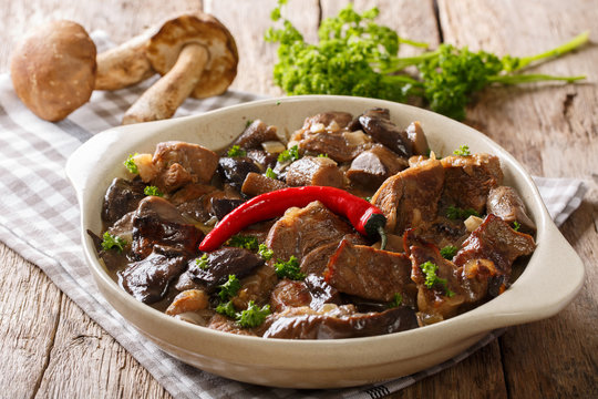Delicious food: beef stew with wild mushrooms in spicy sauce close-up in a bowl. horizontal